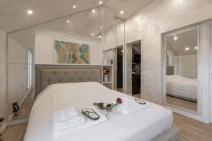 A modern bedroom with a large bed, a mirror, and a painting on the wall. - GARIBALDI, 64 – In the heart of the historic center (Milano)