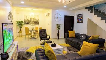 Departamento estándar, balcón, vista a la ciudad | Área de sala de estar | Televisión de pantalla plana