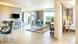 A spacious living area with a flat-screen TV, modern furniture, and large windows offering a view of the outdoors. - Cedarwood Apartment (Abuja)