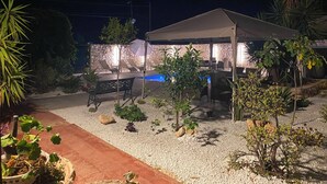 An outdoor patio area with a covered seating area, a pool, and various plants. - Apartment 1-Villa Augusta del Sol (Fontane Bianche)