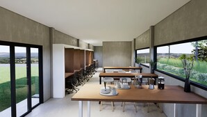 Una sala de reuniones moderna con ventanas amplias, una mesa larga con sillas y vistas al exterior.