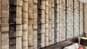 Un interior moderno con pared de diseño geométrico y cabecera de madera oscura.