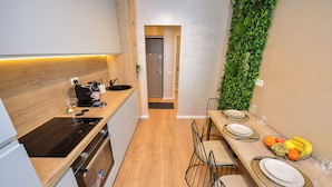 A modern kitchen with wooden countertops, a built-in oven, and a dining area with a long table set for two.