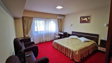 Una habitación de hotel con una cama grande, un escritorio y una silla.