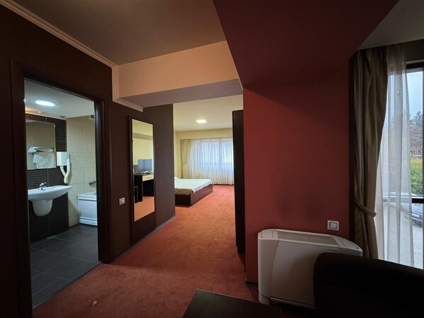 A hotel room with a bathroom, a bed, a desk, and a radiator. - Q Art Severus Hotel (Zalau)