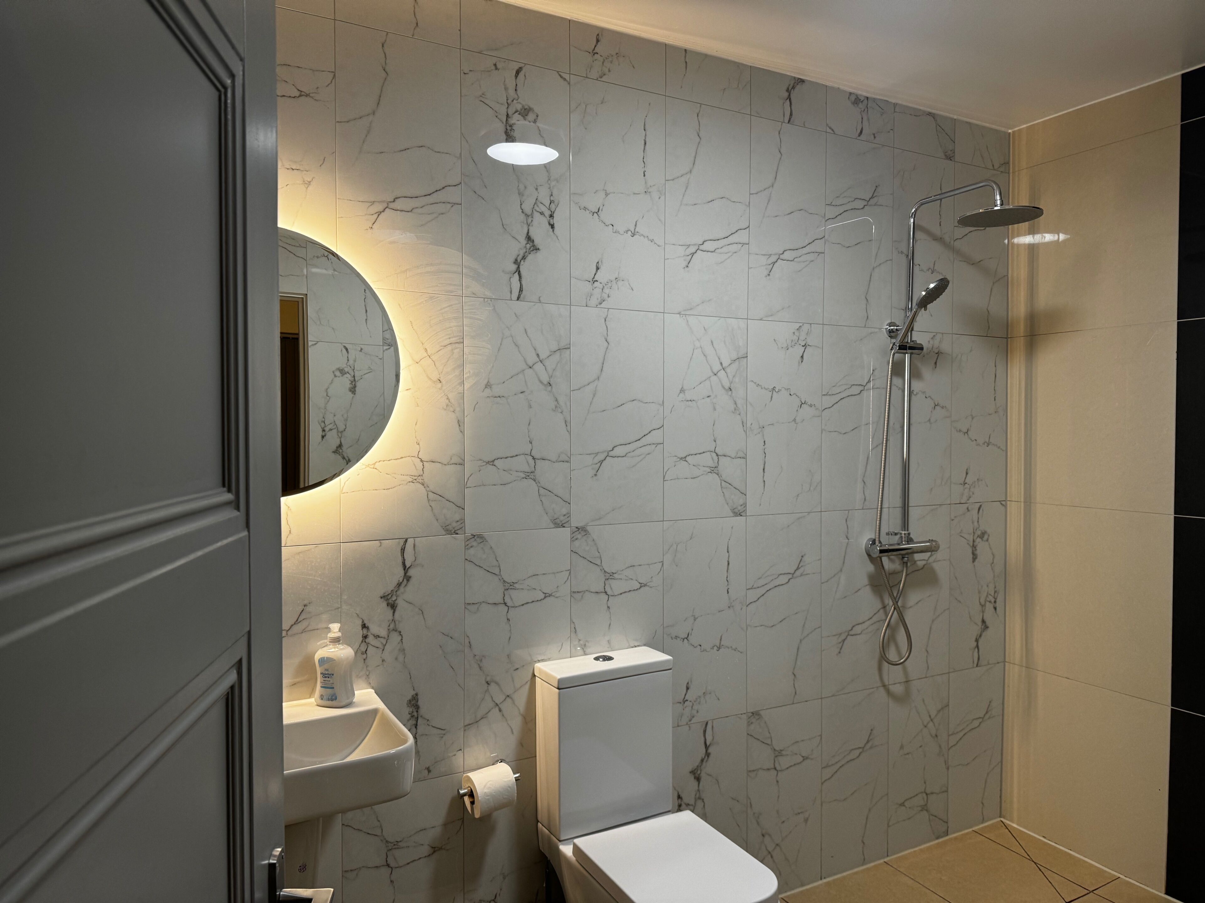 A bathroom with a toilet, sink, and shower.