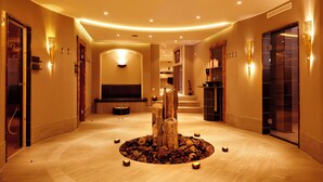 A spacious lobby with a central wooden sculpture, recessed lighting, and a modern design. - NaturPur Hotel Maarblick (Meerfeld)
