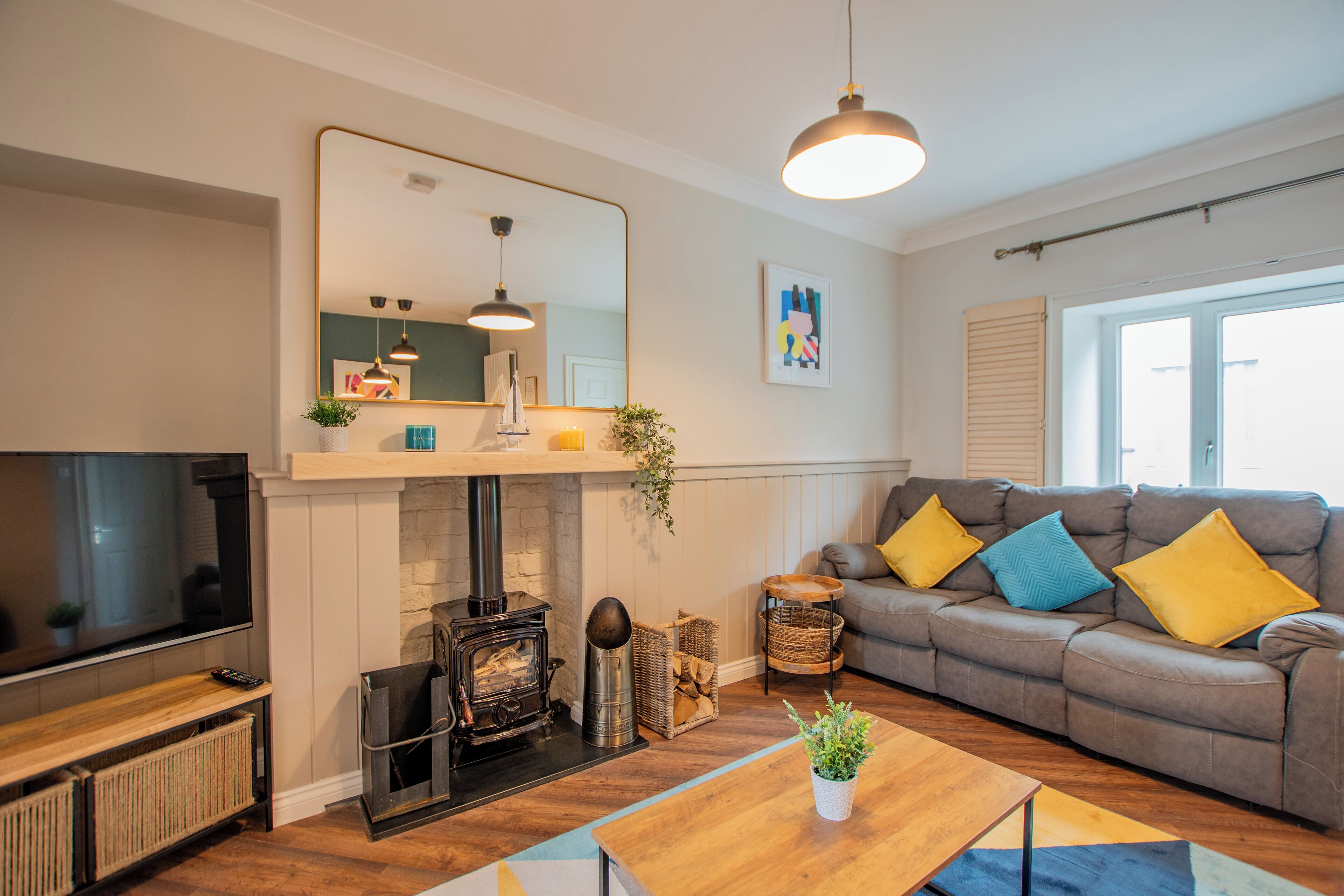 A living room with a fireplace, sofa, and television.