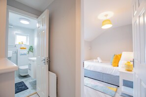 Quarto moderno com cama, mesa de cabeceira e janela.