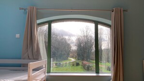 A bedroom with a large window, a bunk bed, and curtains. - Ostal Scrignac - Gîte d'étape de la Gare (Scrignac)
