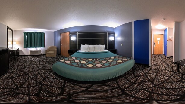 Una habitación de hotel con una cama grande, un escritorio, una silla y una mesita.