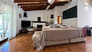 A bedroom with a bed, a TV, a fireplace, and wooden beams on the ceiling. - HOUSE WITH POOL AND ANNEX NEAR THE BEACHES OF ES PUJOLS (ET-41113) (Formentera)