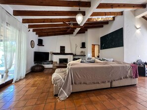 A bedroom with a bed, a TV, a fireplace, and wooden beams on the ceiling. - HOUSE WITH POOL AND ANNEX NEAR THE BEACHES OF ES PUJOLS (ET-41113) (Formentera)