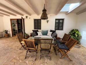A patio with a glass table surrounded by wooden chairs, a hanging light fixture, and potted plants. - HOUSE WITH POOL AND ANNEX NEAR THE BEACHES OF ES PUJOLS (ET-41113) (Formentera)