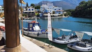 Un puerto deportivo con barcos amarrados, una vista despejada del agua y edificios al fondo.
