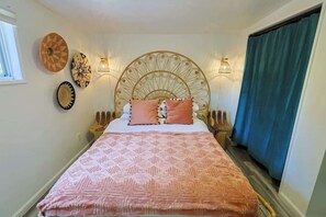 A bedroom with a bed, headboard, wall decorations, and a window. - Topanga 1BR Bungalow | Canyon Views + Loft | C&C (Topanga)