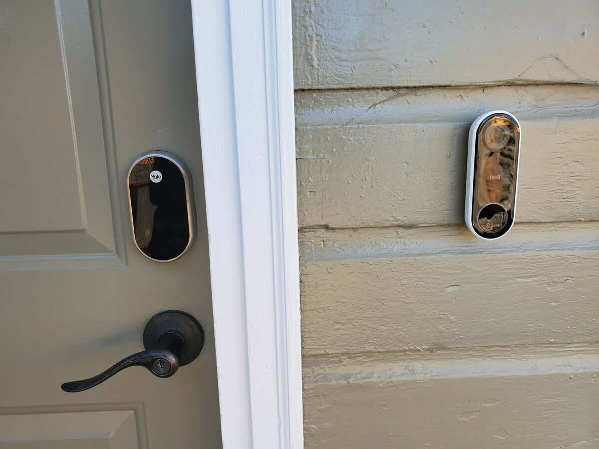 Una puerta con una cerradura Yale y un timbre Nest.