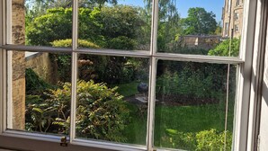 Ein Fenster mit Blick auf einen Garten und ein Gebäude.