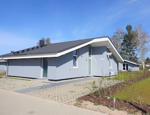 A single-story building with a sloped roof, a front door, and a small porch area.