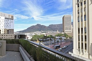 A cityscape with modern buildings, a clear sky, and a mountain in the distance. - 1-Bed Hideaway | High-Rise with City Views (Cape Town)