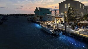 A waterfront property with a dock, boats, and a building with a balcony. - Mermaid Manor ~ Waterfront Haven w/ Hot Tub & Dock (Marathon)