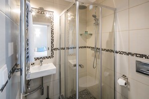 A modern bathroom with a glass-enclosed shower, a white sink, and a mirror above it. - Casa Milhafre - Apartment overlooking Benagil Beac (Benagil)