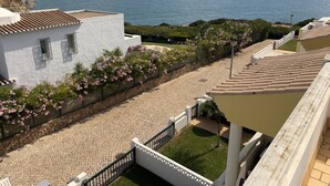 A coastal property with a paved pathway, white buildings, and a view of the sea. - 22 Terraços de Benagil (Casa Liz) (Benagil)