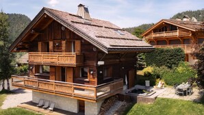 A wooden chalet with a balcony, a hot tub, and a dining area. - 4★ Chalet, 10 ppl, spa, close to slopes, pets allowed (La Clusaz)
