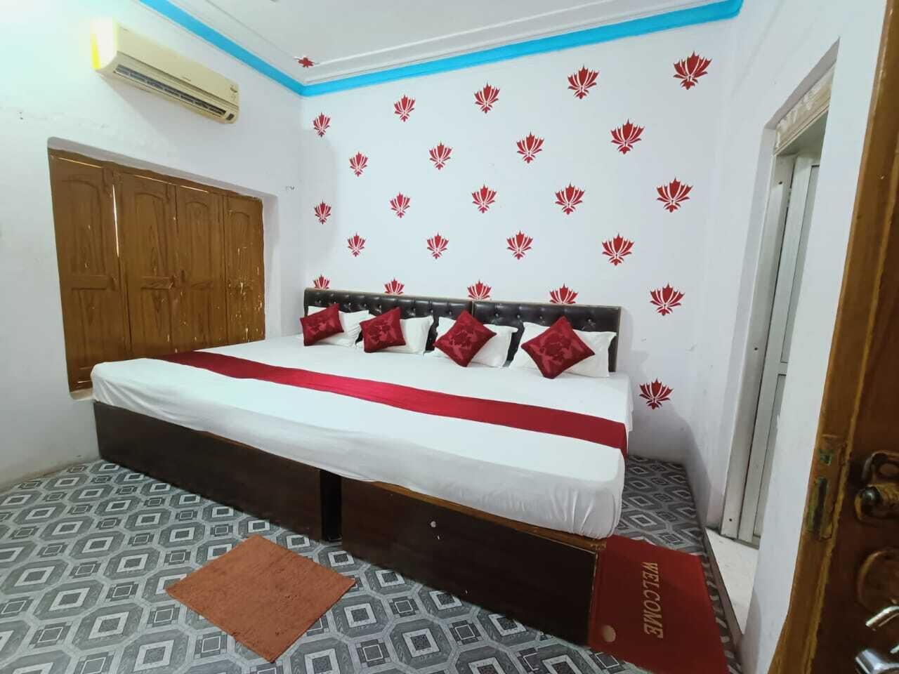 Een slaapkamer met een bed, een kledingkast, vloer met patroon en een muur met rode bloemstickers.