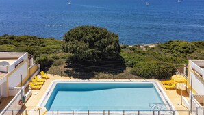 A swimming pool with a view of the sea and a tree in the foreground. - 45 Terraços de Benagil (Casa Céu Azul) (Benagil)