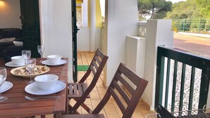 An outdoor dining area with a wooden table set for two, chairs, and a grill. - 45 Terraços de Benagil (Casa Céu Azul) (Benagil)