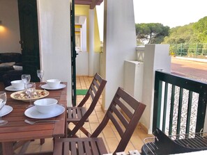 An outdoor dining area with a wooden table set for two, chairs, and a grill. - 45 Terraços de Benagil (Casa Céu Azul) (Benagil)
