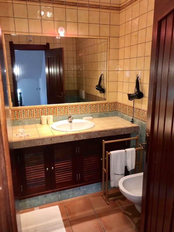 A bathroom with a large mirror, a sink, a hairdryer, and a toilet. - 45 Terraços de Benagil (Casa Céu Azul) (Benagil)