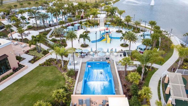An aerial view of a resort with a central pool, water park, and surrounding palm trees. - 2315  Amazing house 6/5 W/Pool Solara Resort (Kissimmee)