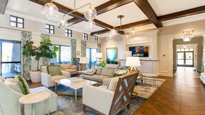 A spacious living room with a high ceiling, large windows, and a television. - 2315  Amazing house 6/5 W/Pool Solara Resort (Kissimmee)