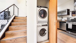 A compact kitchen with a microwave, stove, and a washing machine.