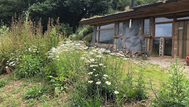 A rustic cabin with a sloped roof, large windows, and a chimney. - Monument Field South Brent (South Brent)