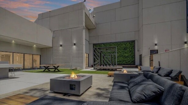 An outdoor patio area with a fire pit, seating, and a view of a modern building. - Chic 1-bedroom apartment with fitness room and AC in vibrant Houston (Houston)