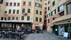 A courtyard with outdoor seating, a pizzeria, and a sign for a local restaurant.