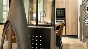 Una cocina moderna con estufa de leña, un comedor con vistas y una pared decorativa.