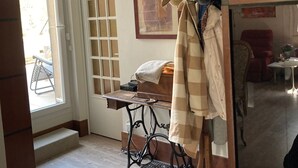 Une pièce où l’on trouve une machine à coudre, un chapeau posé sur un présentoir et un tableau encadré accroché au mur.