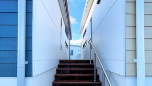 A narrow stairway with metal railings leading to a higher level. - Resort on Cedar (Windang)