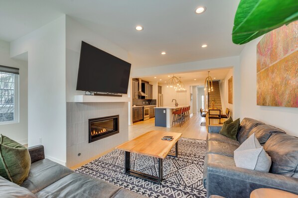 A modern living room with a fireplace, a large flat-screen TV, and a cozy seating area. - 13 Mi to Boulder: Family-friendly Home in Erie! (Erie)