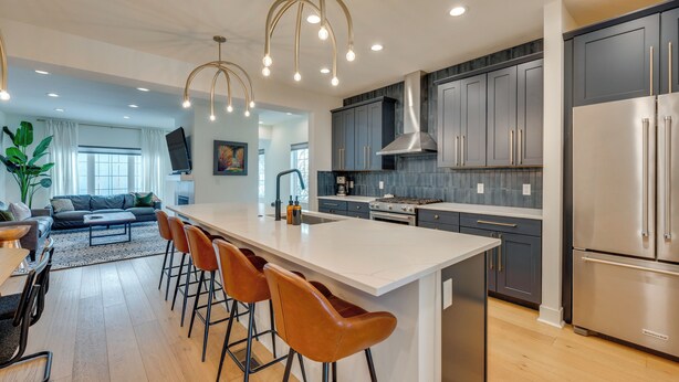 A modern kitchen with a large island, bar stools, and stainless steel appliances. - 13 Mi to Boulder: Family-friendly Home in Erie! (Erie)