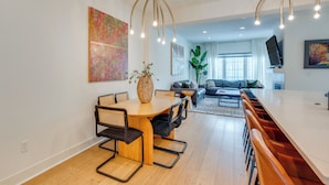A modern living room with a dining area, a sofa, a TV, and artwork on the walls. - 13 Mi to Boulder: Family-friendly Home in Erie! (Erie)
