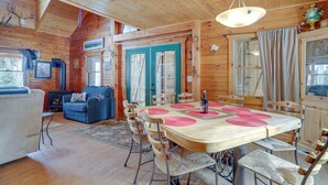 A wooden cabin interior with a dining area, a sofa, and a fireplace. - 2 Mi to Skiing: Casper Cabin w/ Mtn Views! (Casper)