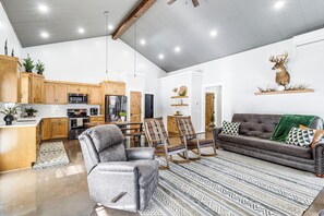 A spacious living area with a gray sofa, two armchairs, and a patterned rug. A deer head is mounted on the wall above the sofa. - Family Retreat w/ Fire Pit & Yard in Mineral City (Mineral City)