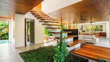 Ein modernes Interieur mit Treppe, Wohnbereich und Küche.