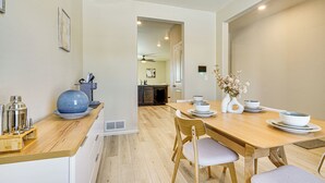 A modern kitchen with a wooden countertop, a dining table with chairs, and a vase with flowers. - Hike, Sightsee & Explore: Home in Colorado Springs (Colorado Springs)