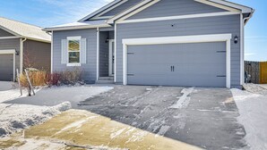 A residential garage with a grey exterior and a white garage door. - Hike, Sightsee & Explore: Home in Colorado Springs (Colorado Springs)